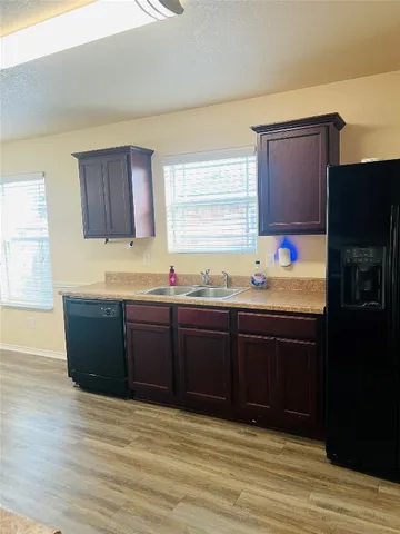 a kitchen with granite countertop wooden cabinets and sink