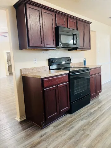 a kitchen with stainless steel appliances granite countertop wooden cabinets and a stove top oven