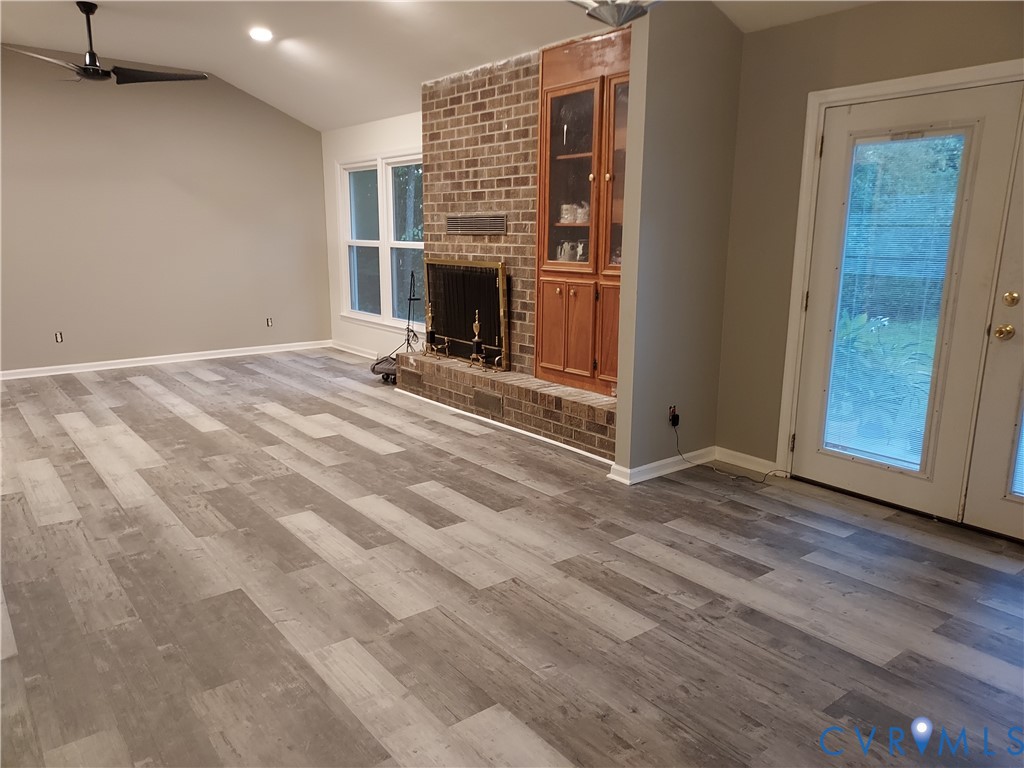 22417 Cox Road Sutherland, VA 23885 - Photo 9 of 22 a view of a livingroom with wooden floor and a fireplace