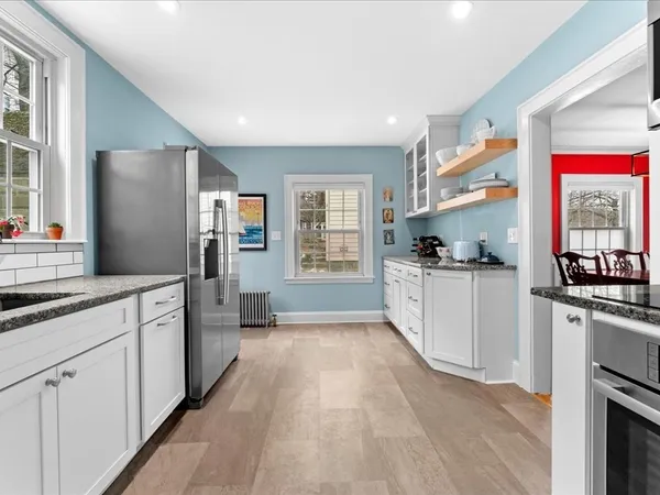 a large kitchen with cabinets wooden floor and stainless steel appliances