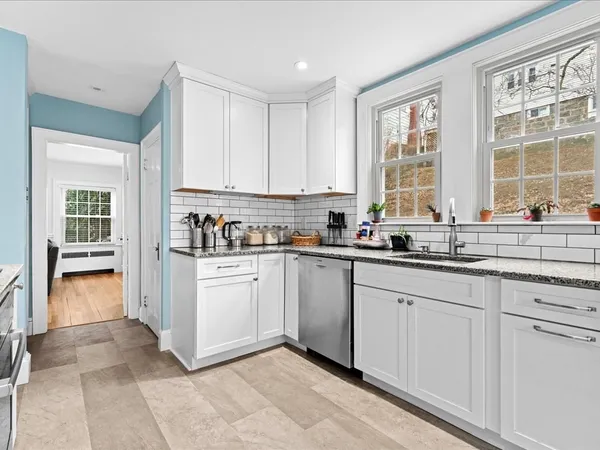 a kitchen with granite countertop white cabinets and white appliances