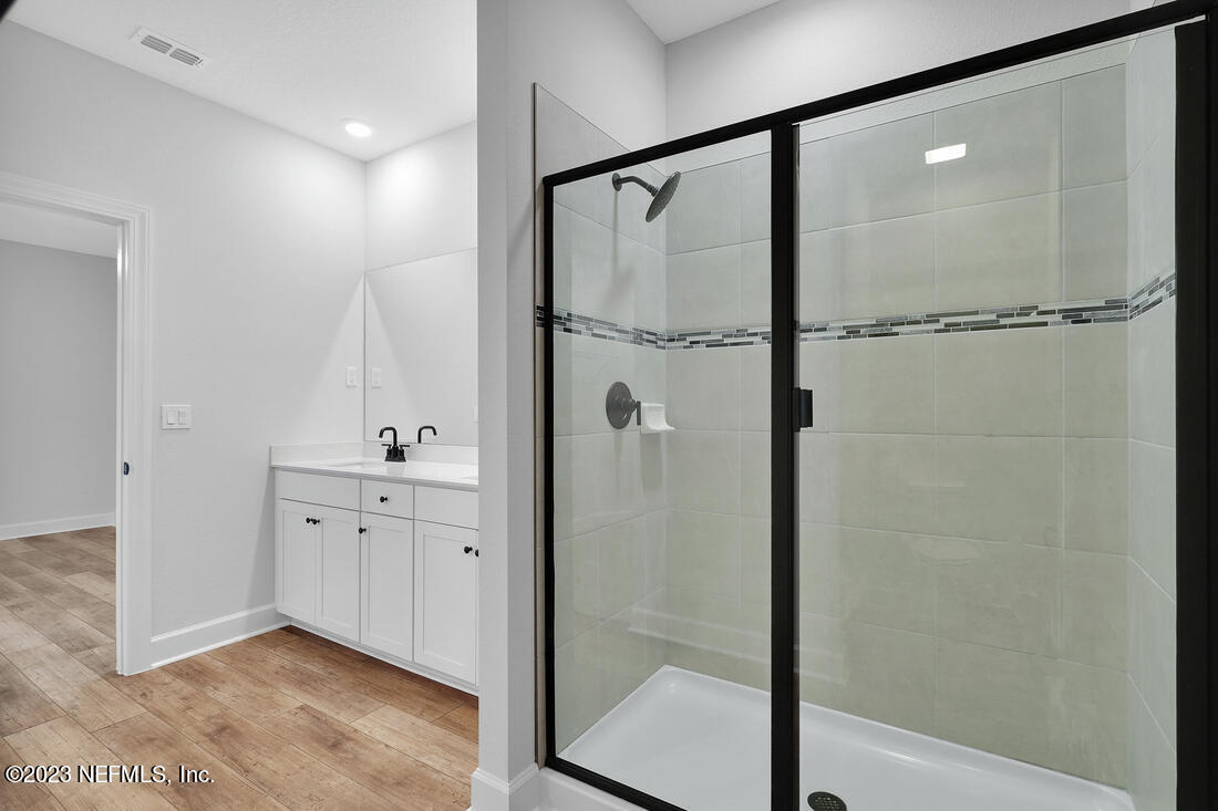 1084 Morgans Treasure Road St. Augustine, FL 32084 - Photo 10 of 11 a bathroom with a double vanity sink a mirror and shower