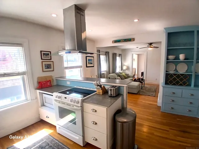 a kitchen with stainless steel appliances granite countertop a stove and a wooden floors