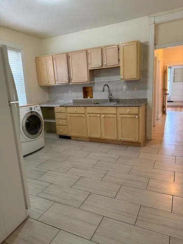 a kitchen with a sink a stove top oven and cabinets