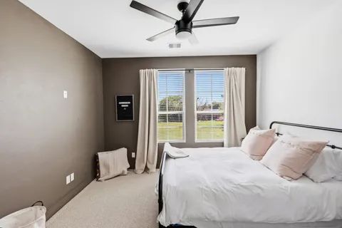 a large bed sitting in a bedroom next to a window