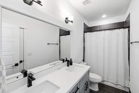 a bathroom with a sink toilet a mirror and shower