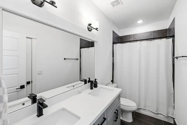 a bathroom with a sink toilet a mirror and shower