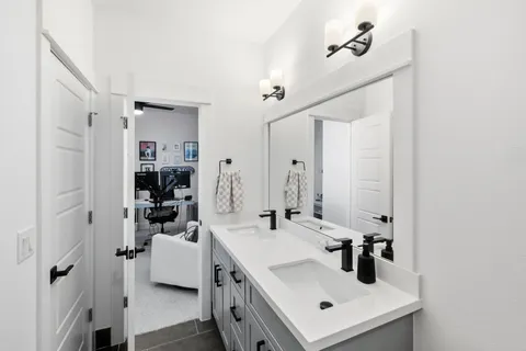a bathroom with a sink a mirror a vanity and shower