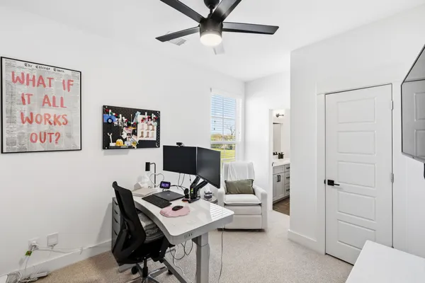 a view of a workspace with furniture and a window
