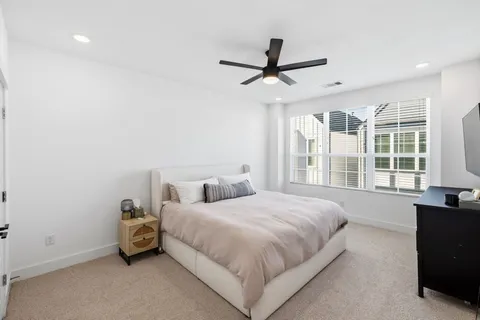 a bedroom with a bed and a large window