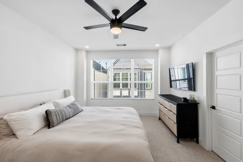 a spacious bedroom with a bed and a large window