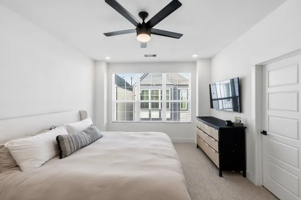 a spacious bedroom with a bed and a large window