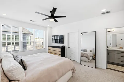 a bedroom with a large bed and a chandelier