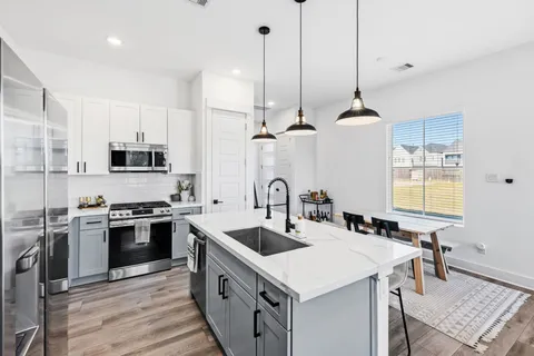 a kitchen with stainless steel appliances a stove a sink a oven a counter space and cabinets