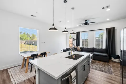 a view of a kitchen island a sink a table and chairs