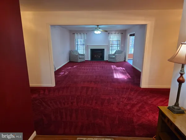 a view of an empty room with window and fireplace