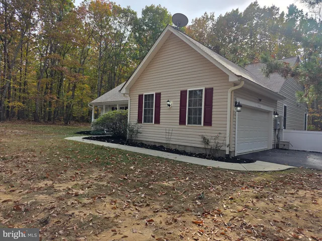 a view of a house with a yard and large tree