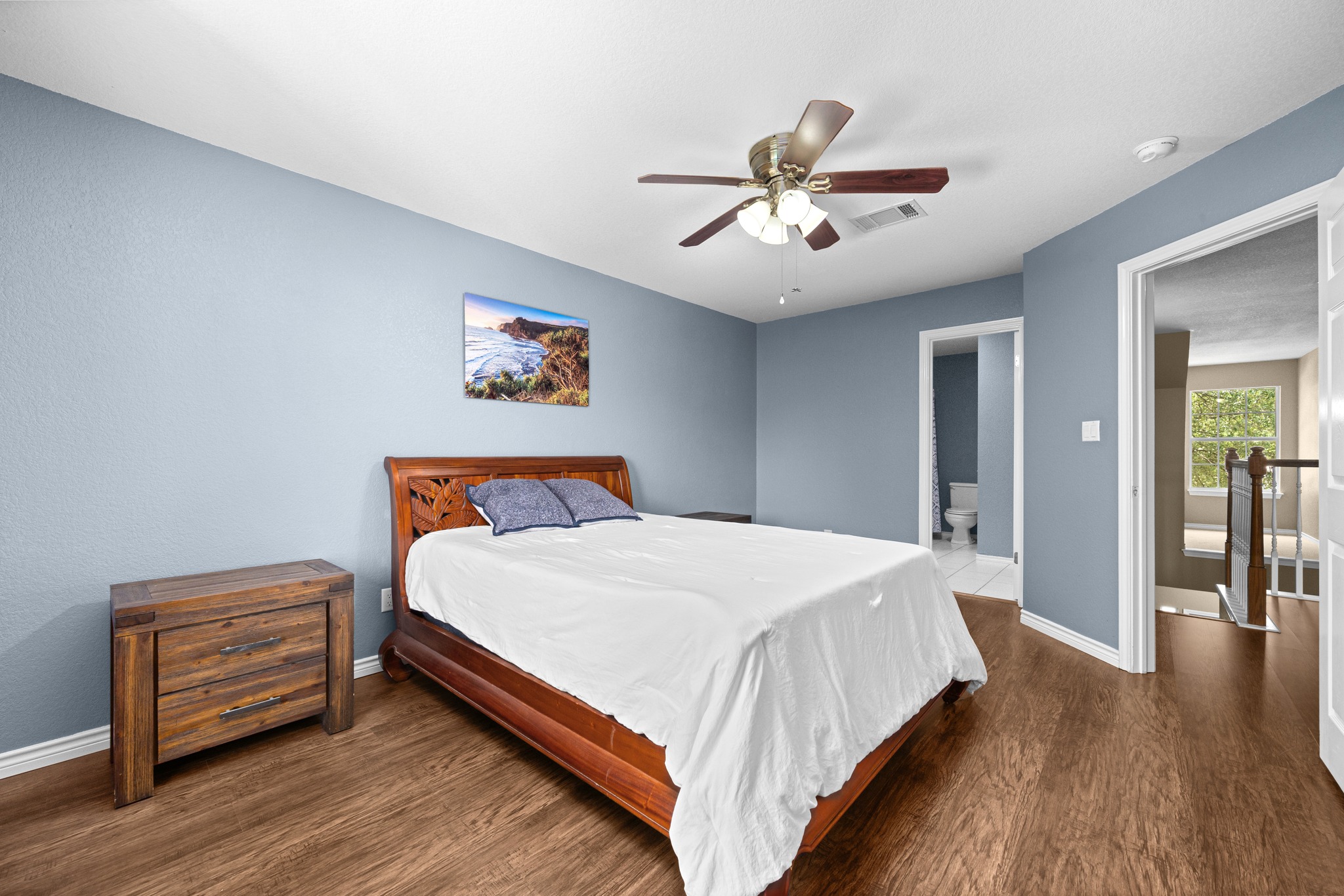 108 Thornwood Road Georgetown, TX 78628 - Photo 32 of 40 Hardwood floors and a ceiling fan enhance this inviting bedroom, with a private bath accessible from the room.