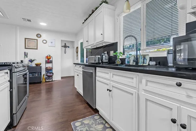 a kitchen with stainless steel appliances granite countertop a refrigerator and a stove