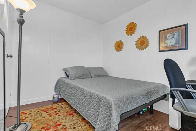 a bedroom with a bed and painting on the wall