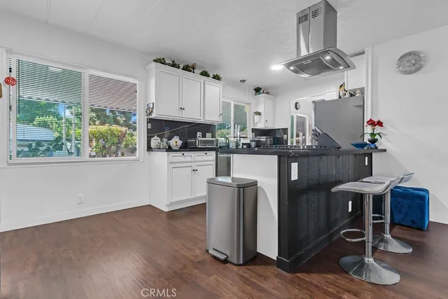 a kitchen with granite countertop a table chairs a stove a sink and a window