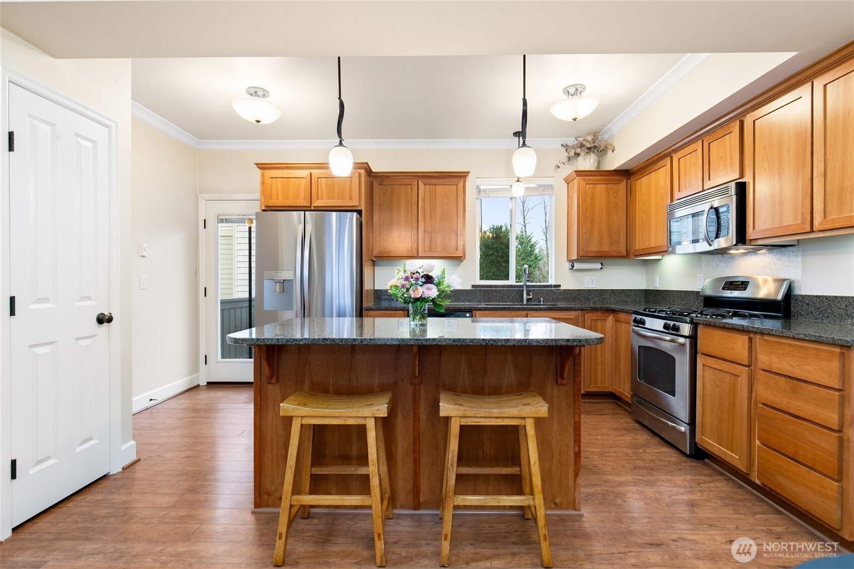 320 Chelan Place Northeast, Unit H1 Renton, WA 98059 - Photo 7 of 30 a kitchen with stainless steel appliances granite countertop wooden floors and white cabinets