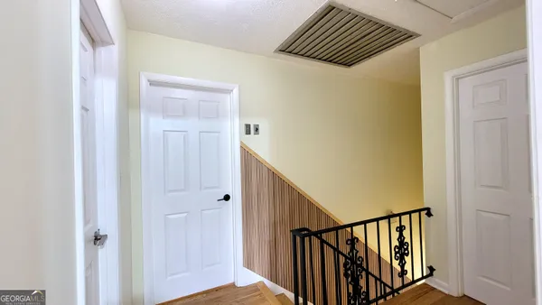 a view of a hallway with wooden floor and staircase
