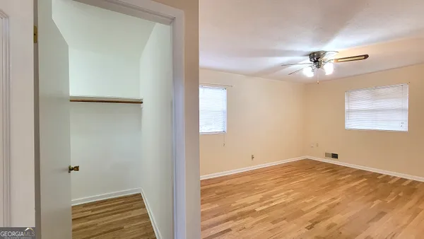 a view of empty room with wooden floor
