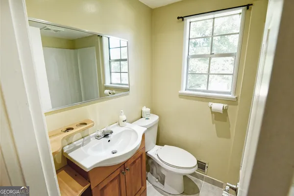 a bathroom with a sink toilet and mirror