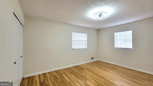 a view of empty room with wooden floor