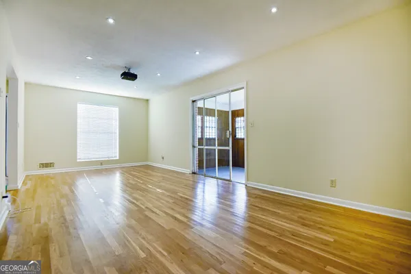 an empty room with wooden floor and windows