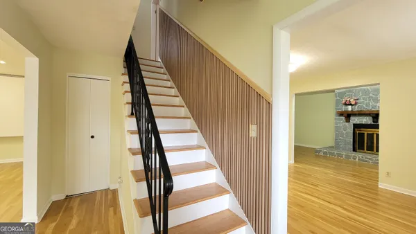 a view of a hallway with wooden floor and staircase