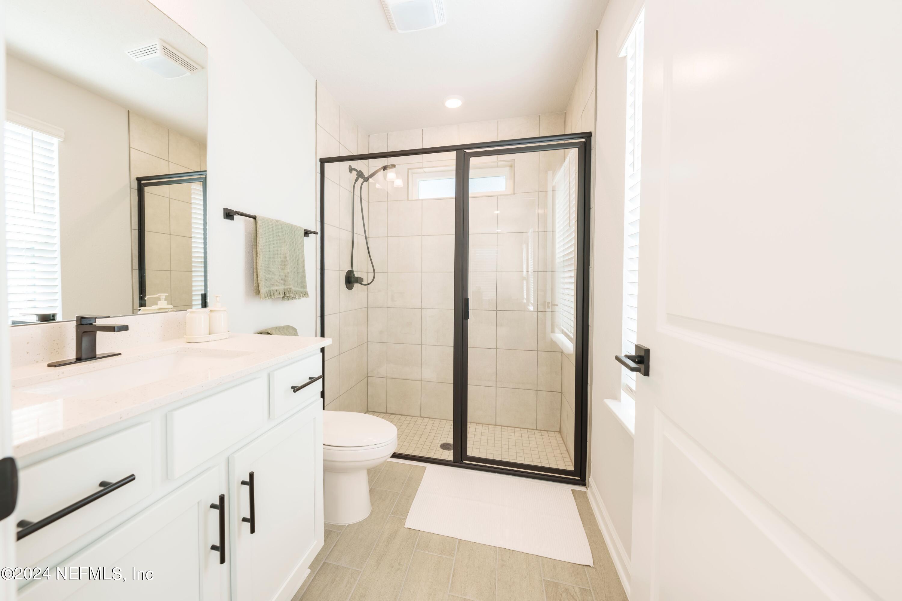 159 Barstow Place Jacksonville, FL 32204 - Photo 12 of 35 a spacious bathroom with a shower sink and mirror