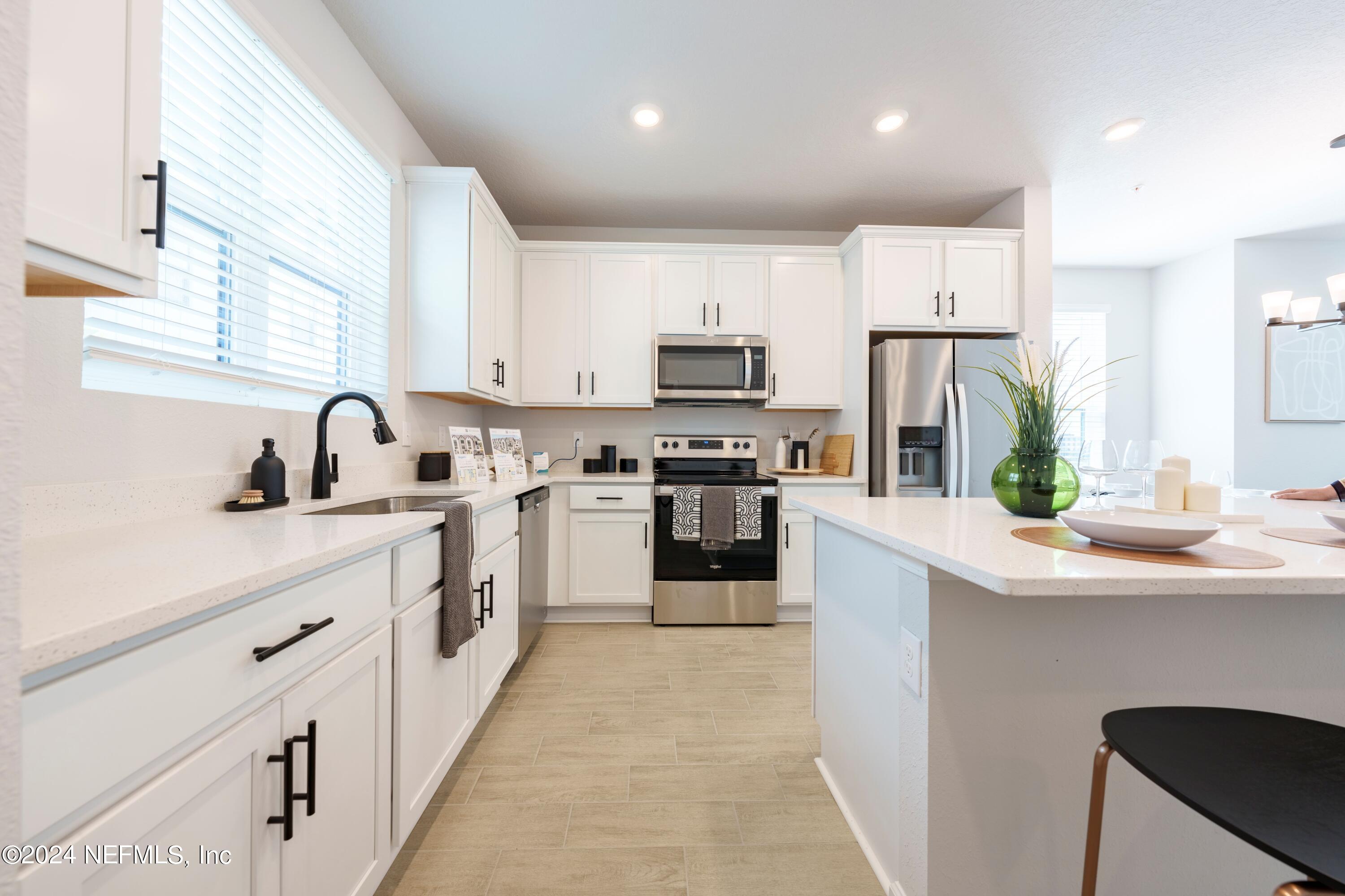 159 Barstow Place Jacksonville, FL 32204 - Photo 21 of 35 a kitchen with white cabinets stainless steel appliances and sink
