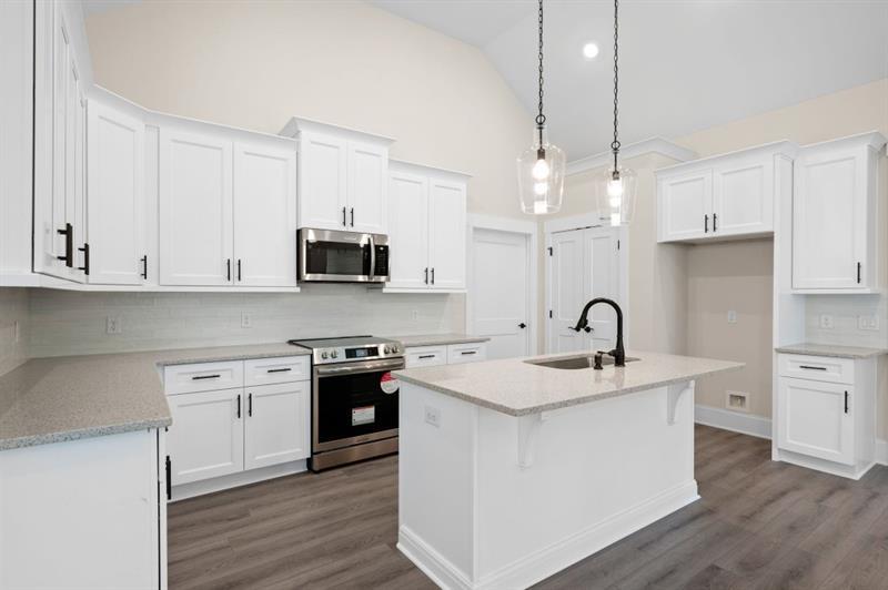 150 Doris Path Temple, GA 30179 - Photo 13 of 36 a kitchen with stainless steel appliances granite countertop a sink stove a refrigerator and white cabinets with wooden floor