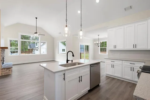 a kitchen that has a sink a window and chairs