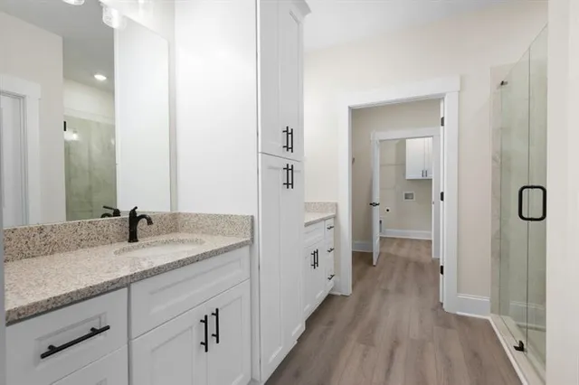 a en suite bathroom with a granite countertop sink mirror and shower