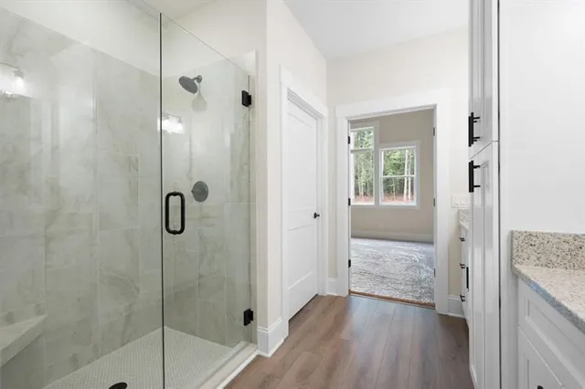 a bathroom with a granite countertop shower a sink and a mirror