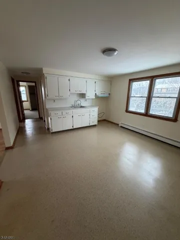 a view of an empty room with a fireplace and a window