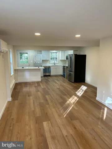 a view of kitchen with refrigerator sink and cabinets
