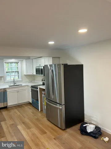 a kitchen with a refrigerator and a stove top oven
