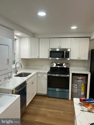 a kitchen with stainless steel appliances a stove sink and microwave