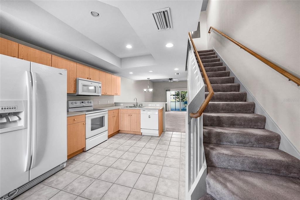 1246 Rio De Janeiro Avenue, Unit 505 Punta Gorda, FL 33983 - Photo 6 of 49 a kitchen with white cabinets and white appliances
