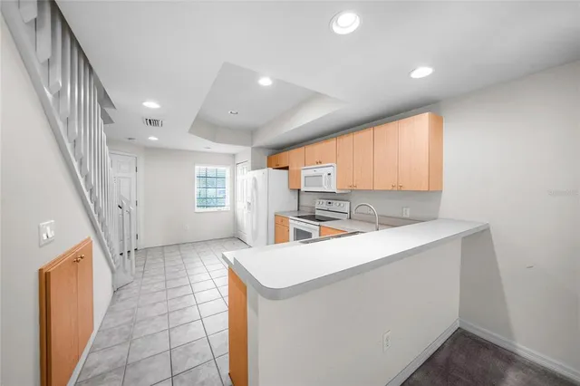 an empty room with chandelier fan and windows