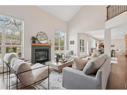 a living room with furniture a fireplace and a large mirror