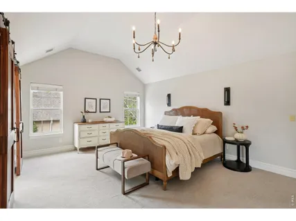 a living room with a bed furniture and next to a window