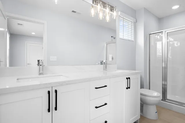 a bathroom with a sink a toilet and shower