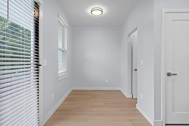 a view of a room with wooden floor and window