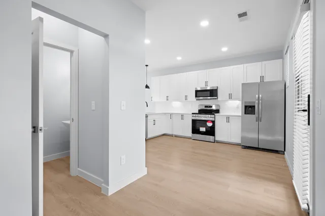 a view of kitchen with refrigerator and cabinets