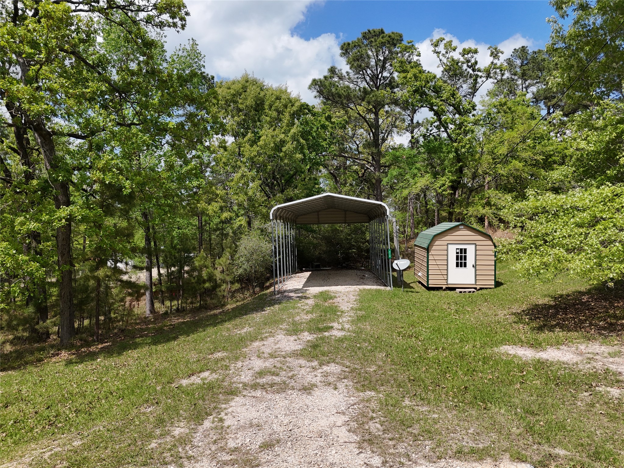 310 Oakwood Lane Trinity, TX 75862 - Photo 15 of 24 a view of a tiny house with a yard and large trees